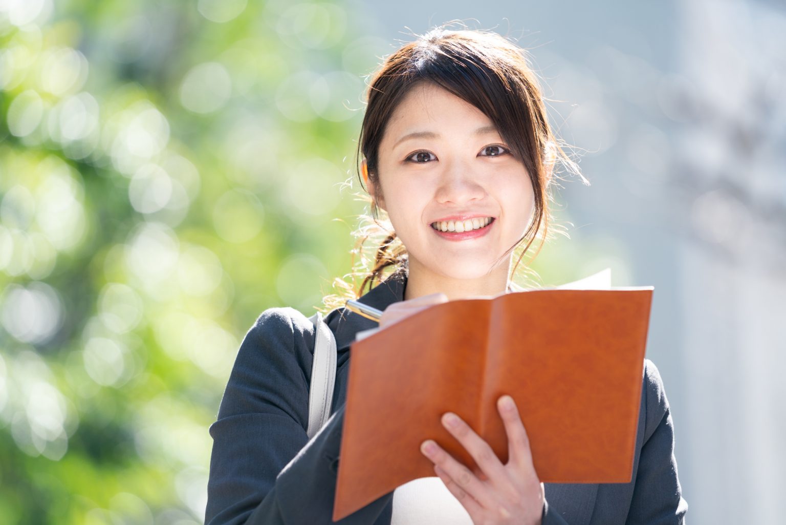 ノートにメモを取る女性