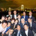 東京湾の夜景をバックに集合写真を撮影