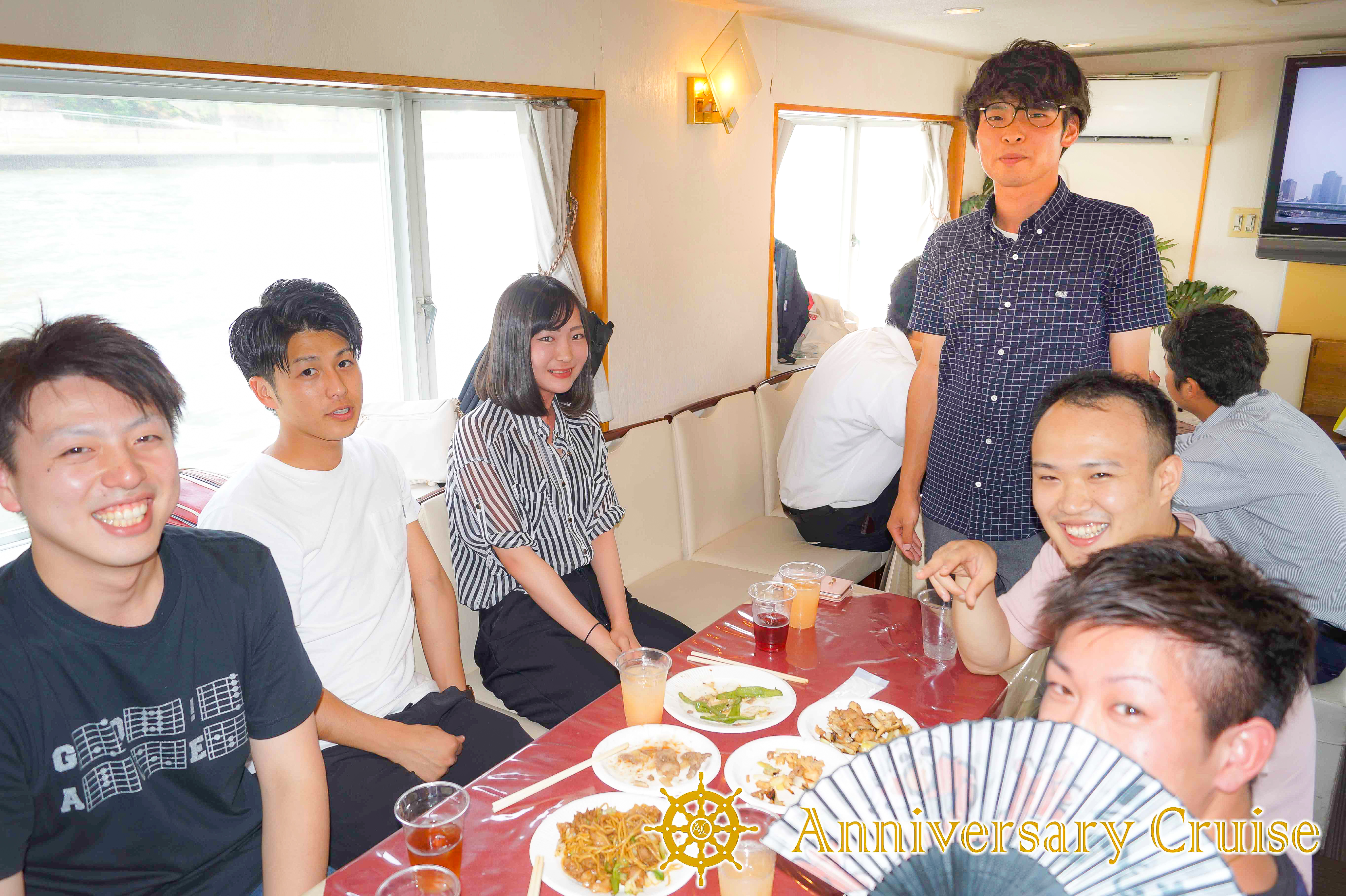 船内でテーブルを囲って話が盛り上がっている男女グループ