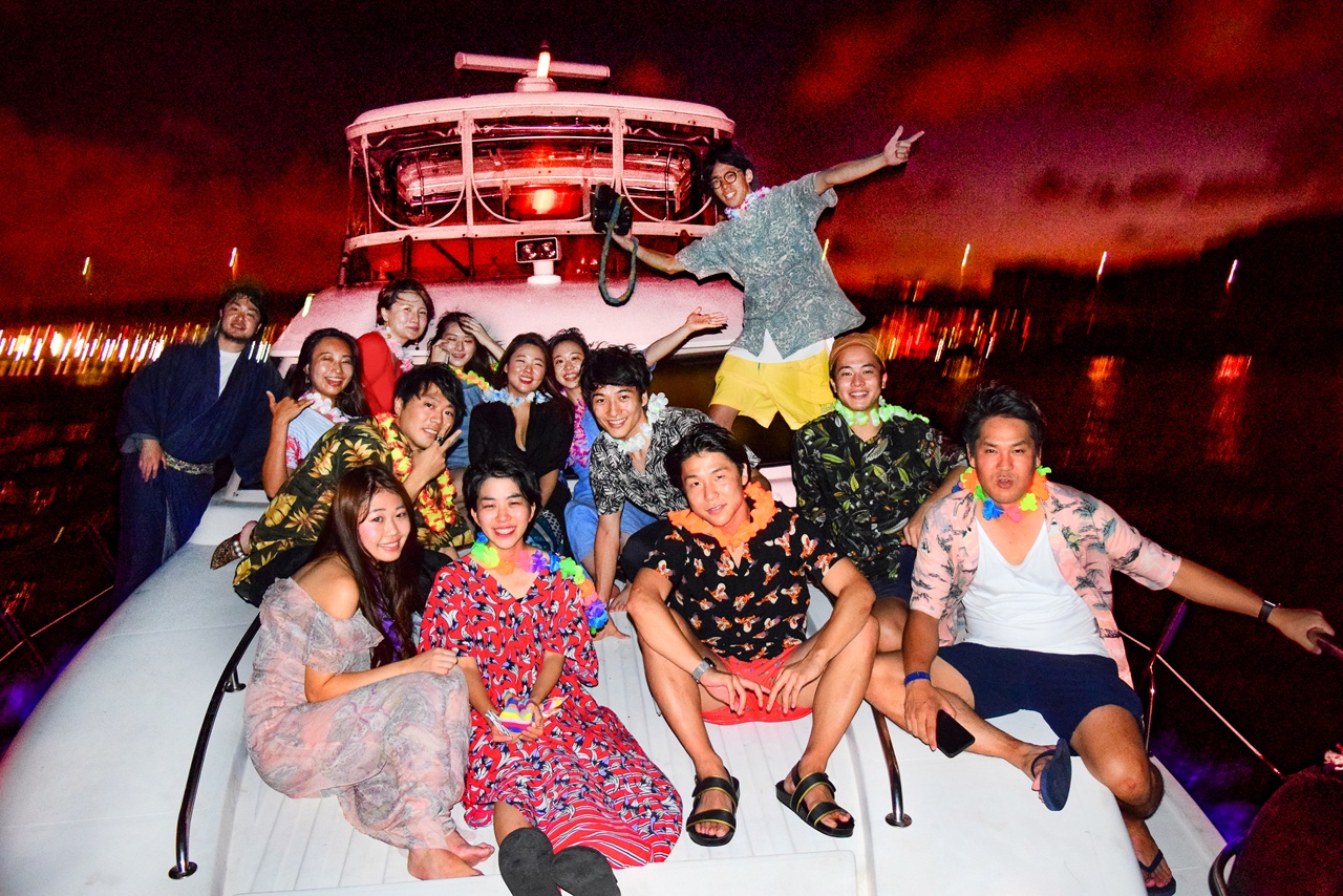 中型クルーザー「ミッドブルー」号で夜景を背景に集合写真