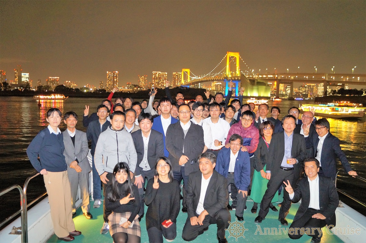 レインボーブリッジを背景に大人数で写真撮影