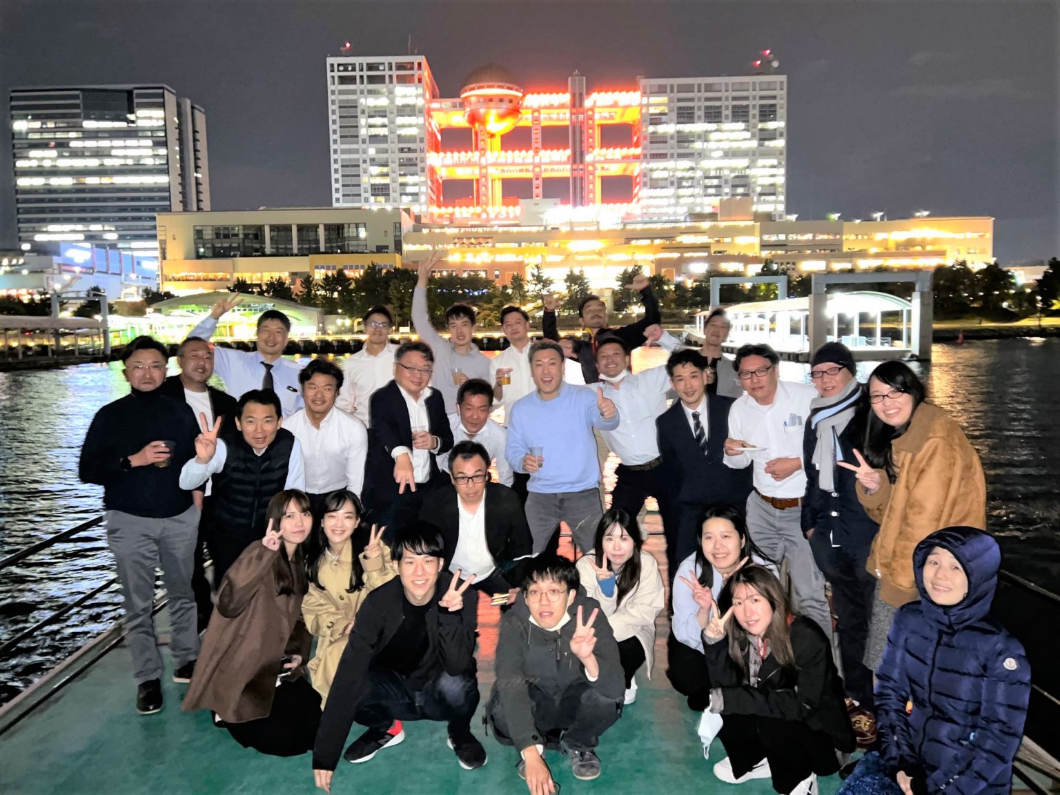フジテレビビルを背景に、船の上で集合写真を撮影