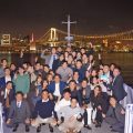 ルーカス号のデッキで集合写真を撮影する。背景にはレインボーブリッジなど東京湾の夜景が広がる。