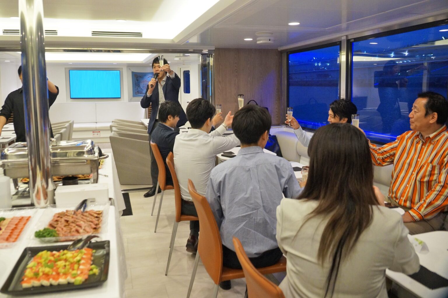 シエルブルー号の船内で乾杯する企業御一行様