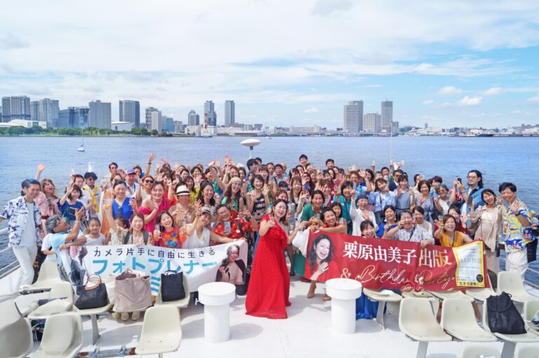 大型クルーザーの屋上デッキで集合写真を撮影する団体