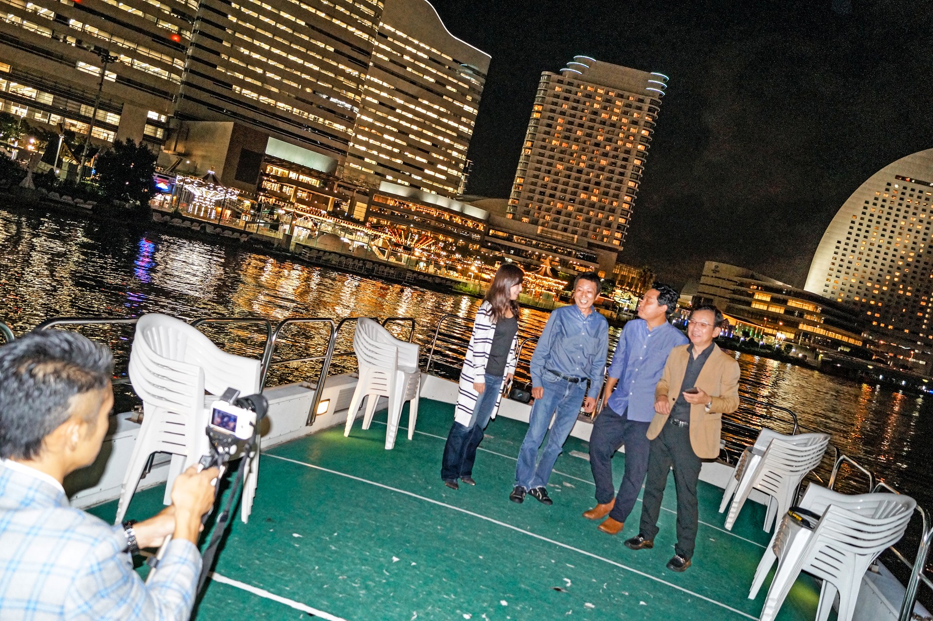 クルーザーのデッキで写真撮影を楽しむ人