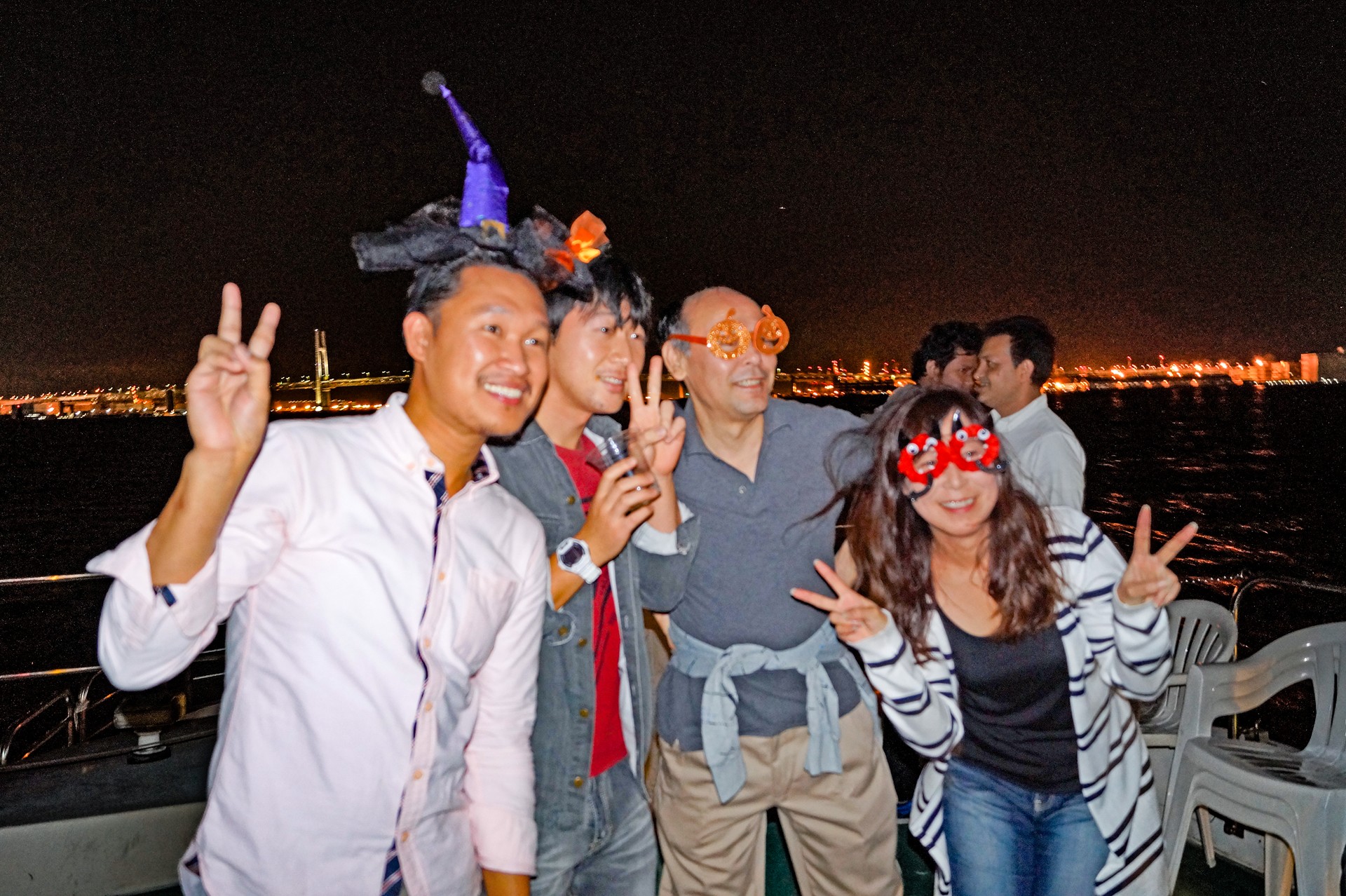 クルーザーのデッキで写真撮影を楽しむ人