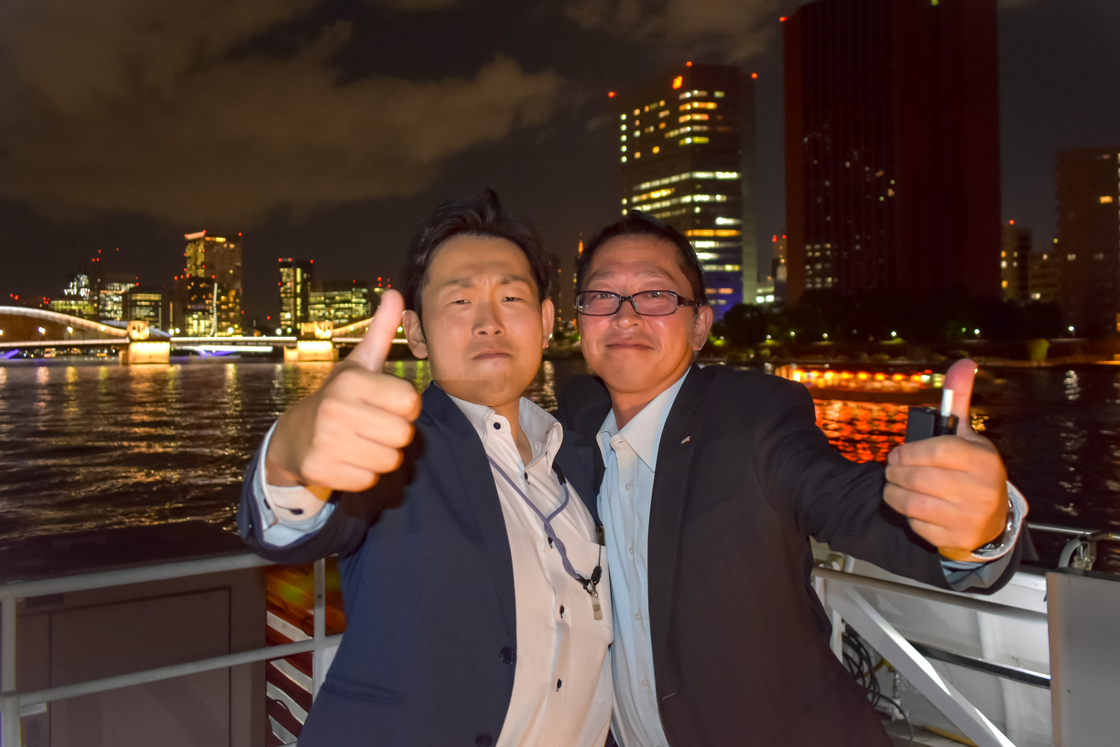 デッキにて夜景をバックにポーズ