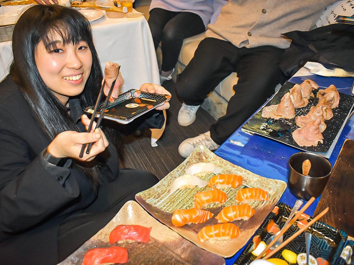 寿司職人のお寿司を食べえる女性