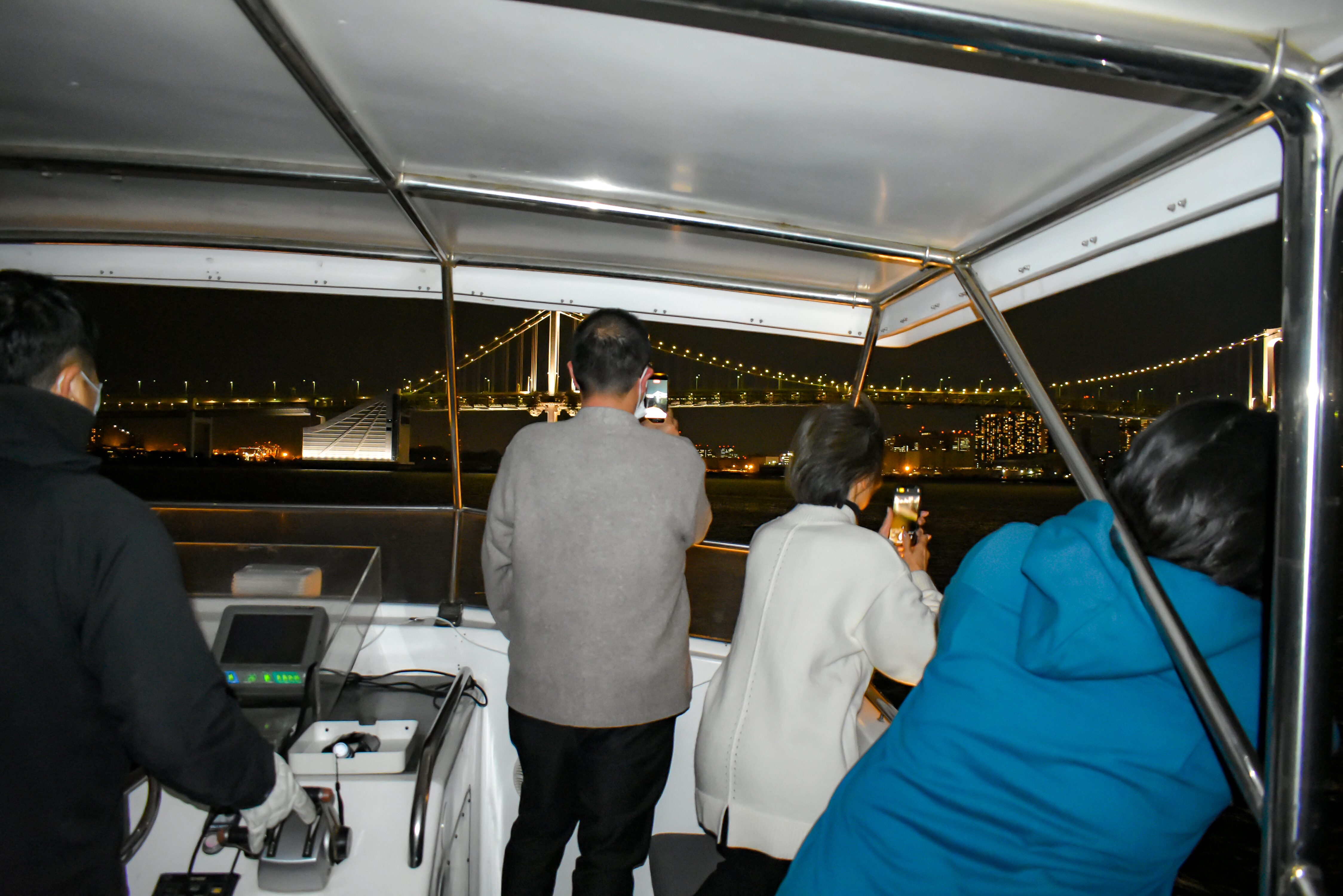 船の上から見る夜景を写真に収める