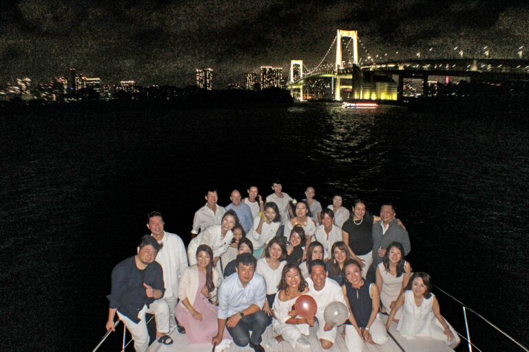 クルーザーのデッキでレインボーブリッジをバックに記念写真