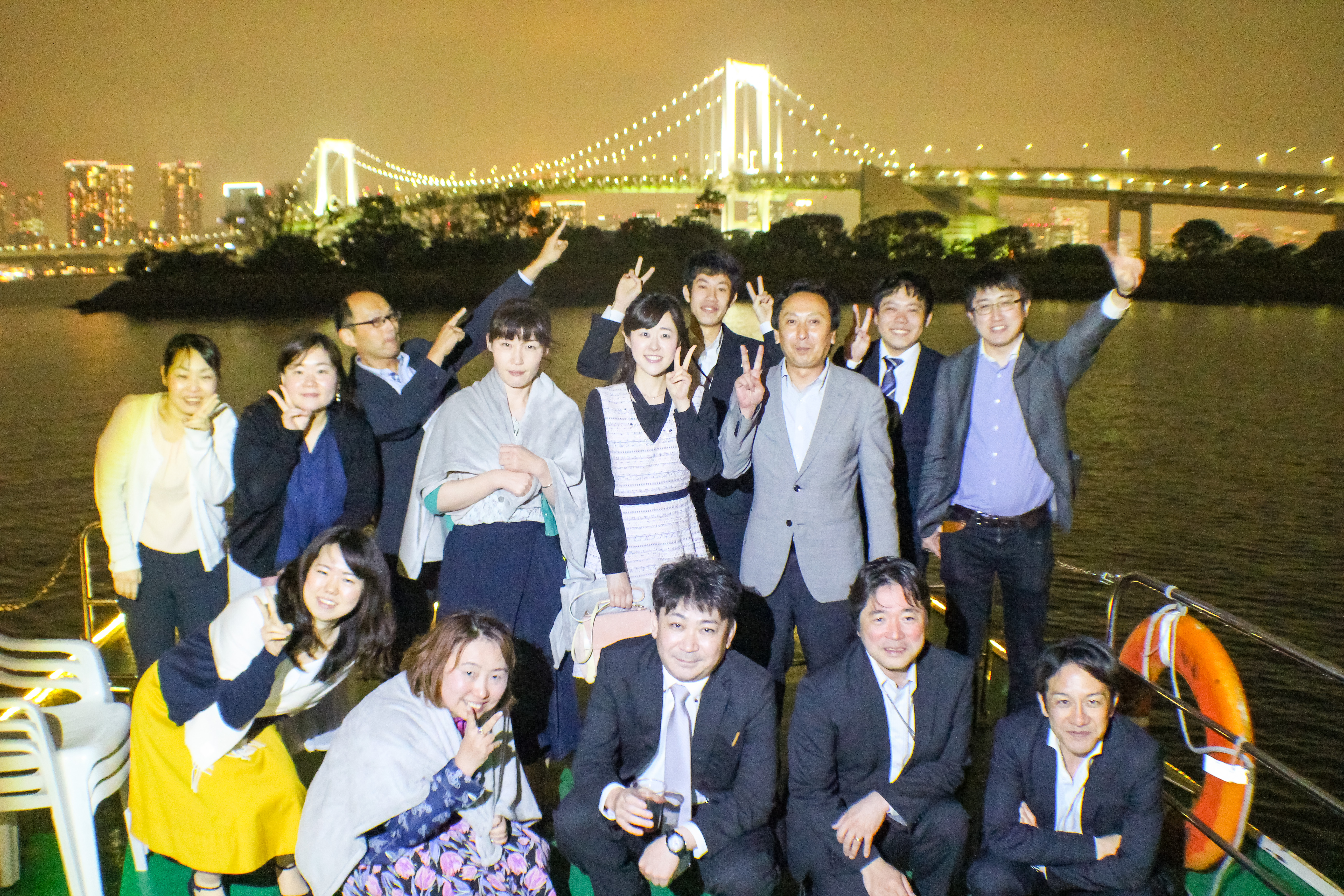 レインボーブリッジの前でデッキで集合写真　