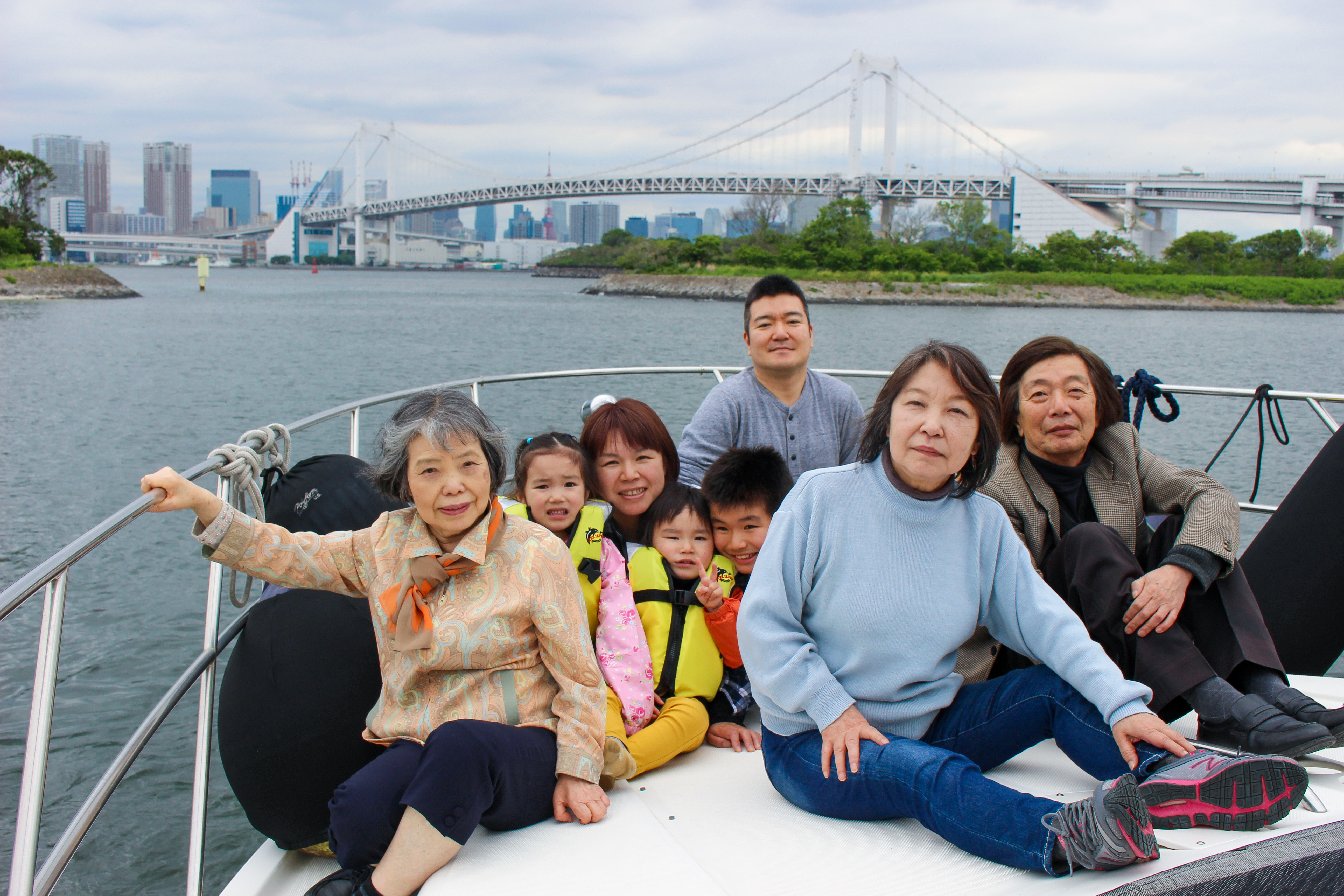 デッキでレインボーブリッジをバックに集合写真