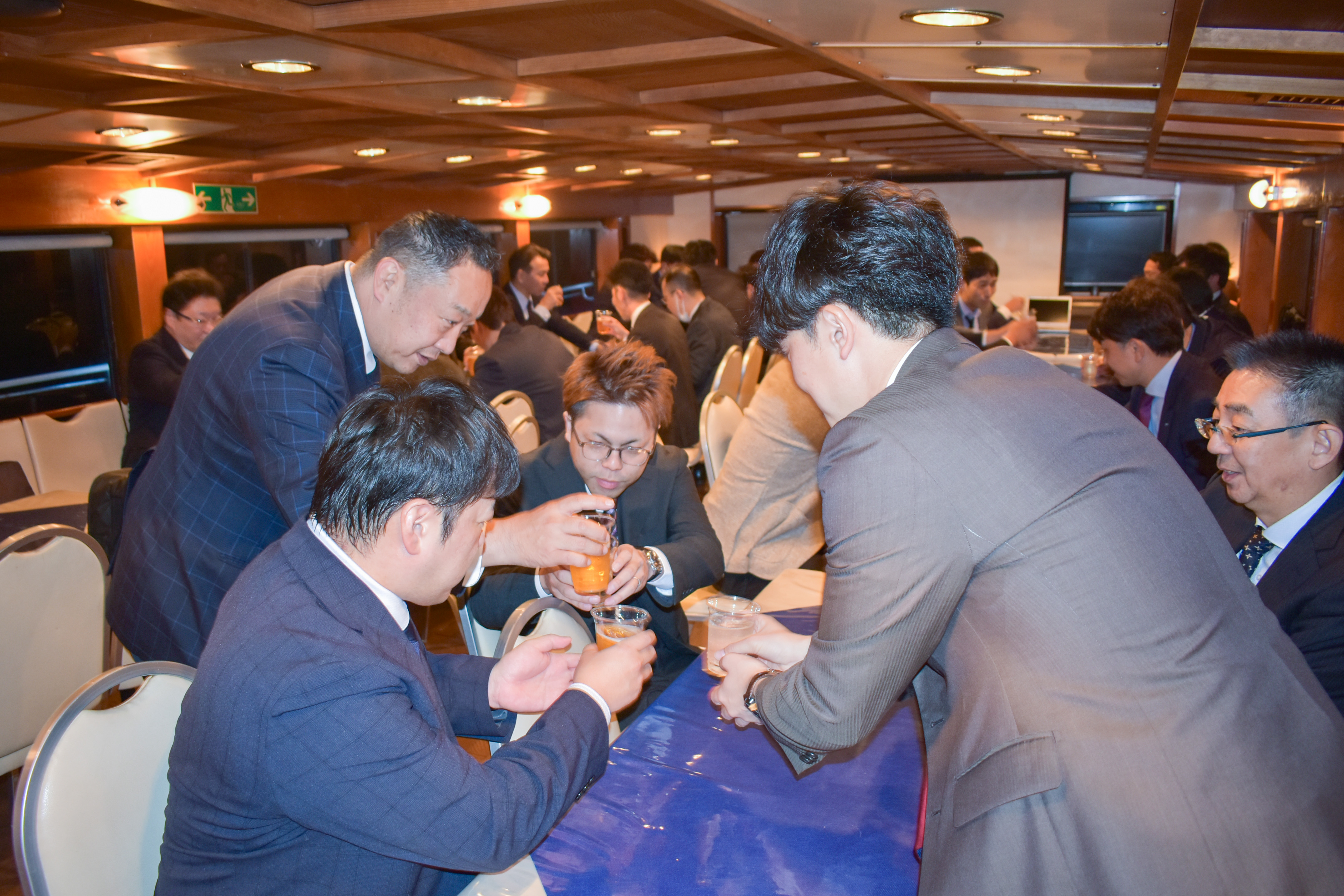 船内で乾杯するスーツの男性たち